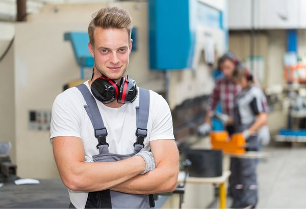 Junger Mann in einer Produktionshalle. Foto: Adobe Stock