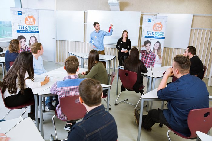 Zwei Personen Präsentieren vor einer Klasse