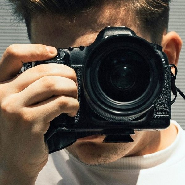 Junger Mann mit Kamera. Foto: Unsplash