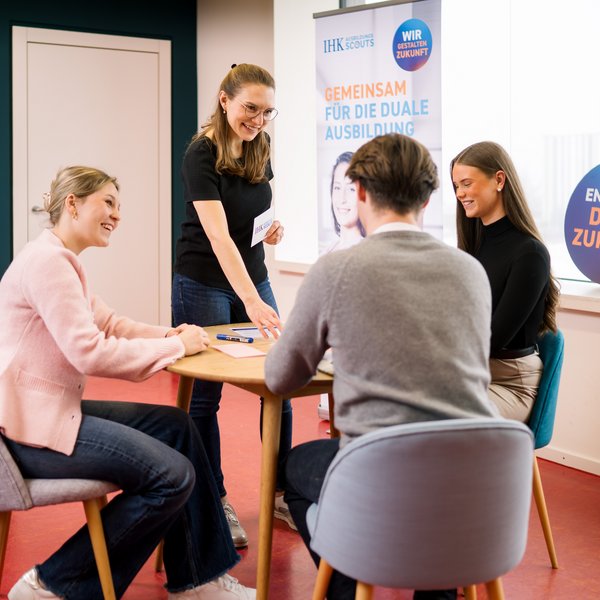 AusbildungsScouts lernen von Regionalkoordinatorin, sitzen an einem Tisch und bereiten sich vor auf Klassenbesuch