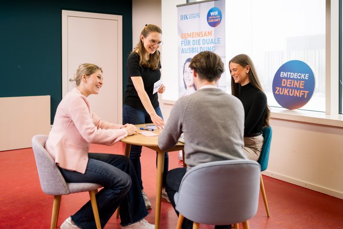 AusbildungsScouts lernen von Regionalkoordinatorin, sitzen an einem Tisch und bereiten sich vor auf Klassenbesuch